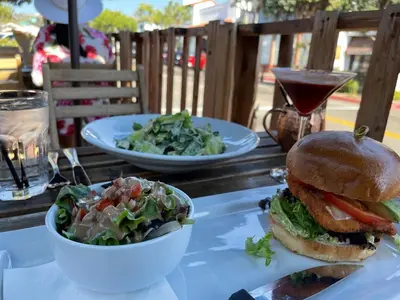 a table with a sandwich and a salad and a drink at Walk To Beach 2BR Top Location - AA in San Clemente