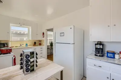 a kitchen with white cabinets and a white refrigerator at Walk to Beach - KING Apt In #1 Area - AB in San Clemente