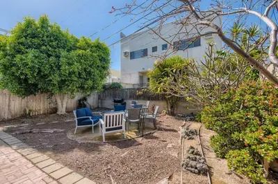 a yard with chairs and a table and a building at Walk to Beach - KING Apt In #1 Area - AB in San Clemente