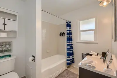 a white bathroom with a tub and a sink at Walk to Beach - KING Apt In #1 Area - AB in San Clemente