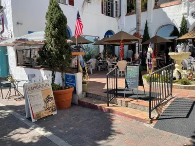 an outdoor patio with tables and umbrellas and a sign at Walk to Beach - KING Apt In #1 Area - AB in San Clemente