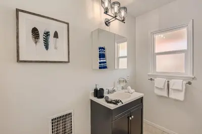 a white bathroom with a sink and a mirror at Walk to Beach - KING Apt In #1 Area - AC in San Clemente
