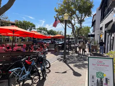 a group of people sitting at a restaurant under umbrellas at Walk to Beach - KING Apt In #1 Area - AC in San Clemente