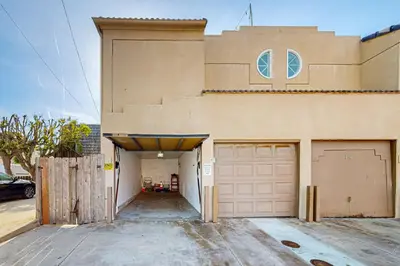 a building with two garage doors and a driveway at Stroll to Shore and Mission Blvd Dog-Friendly Home in San Diego