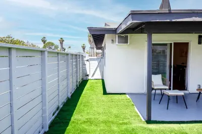 a backyard with a white fence and grass at Gillespie Drive 1063 Unit B by sdstay in Spring Valley