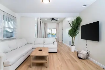 a white living room with a white couch and a table at Newly Built Coastal Home with Yard in San Diego