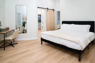 a bedroom with a bed and a desk and a table at Newly Built Coastal Home with Yard in San Diego