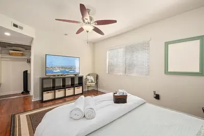 a bedroom with a white bed with a flat screen tv at Mission Hills Dream - BBQ, Patios, AC, Parking in San Diego
