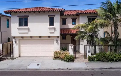 a white house with a gate and a garage at Oceanfront Paradise - Luxury, Fire Pit, Views in San Diego