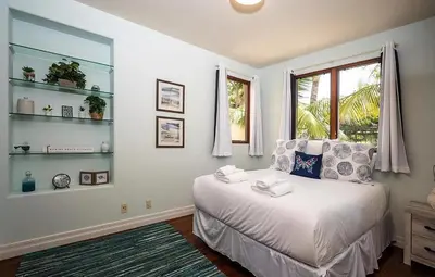 a bedroom with a bed and a window and shelves at Oceanfront Paradise - Luxury, Fire Pit, Views in San Diego
