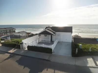 a house on the beach with the ocean in the background at Beachfront Bliss | Shining Sea Condo on The Strand w/ Ocean Views in Oceanside