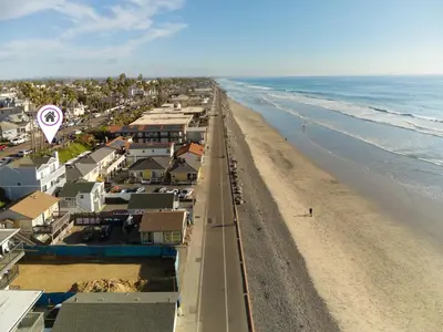 an aerial view of a beach with houses and the ocean at Beachfront Bliss | Shining Sea Condo on The Strand w/ Ocean Views in Oceanside