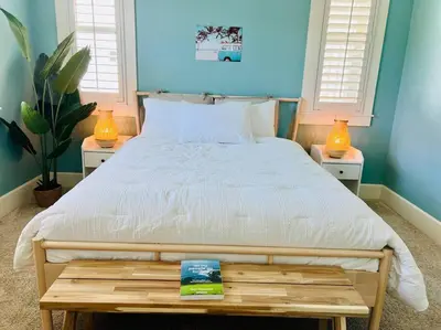 a bedroom with a white bed with two tables and two windows at Getaway Retreat Close to Temecula San Diego LA in Murrieta
