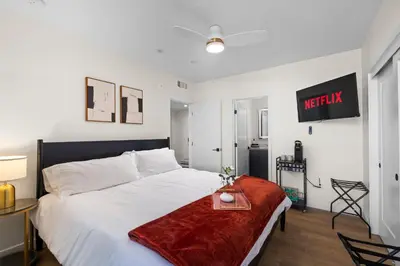 a bedroom with a large white bed with a red blanket at Modern 2 Bedroom King Bed EVCharger Pet-Friendly Balcony in San Diego