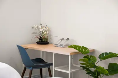 a table with a telephone and a blue chair at Modern 2 Bedroom King Bed EVCharger Pet-Friendly Balcony in San Diego