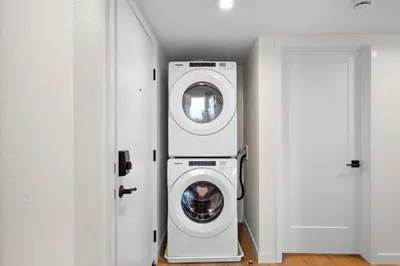 a washer and dryer in a room next to a door at Modern 2 Bedroom King Bed EVCharger Pet-Friendly Balcony in San Diego