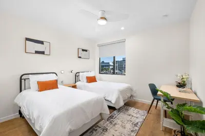 two beds in a white room with a window at Modern 2 Bedroom King Bed EVCharger Pet-Friendly Balcony in San Diego