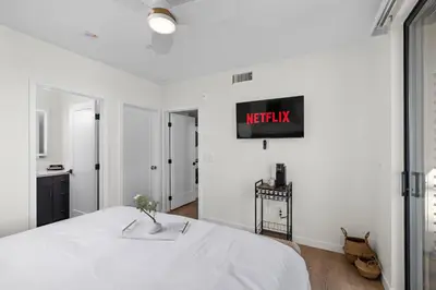 a bedroom with a bed and a tv on the wall at Stylish 2 Bedroom King Bed EVCharger Pet-Friendly Balcony in San Diego