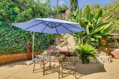 a table and chairs with a blue umbrella at Amazing Views with massive pool Total Oasis in La Mesa
