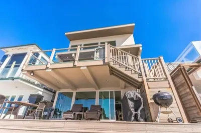 a house with a balcony with chairs on the stairs at Massive 3 bedroom on the sand-STR14-0133 in Dana Point
