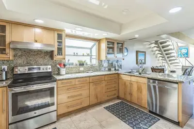 a kitchen with wooden cabinets and stainless steel appliances at Massive 3 bedroom on the sand-STR14-0133 in Dana Point
