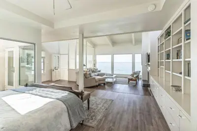 a bedroom with a large bed and a living room at Massive 3 bedroom on the sand-STR14-0133 in Dana Point