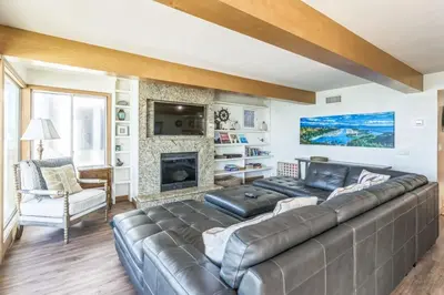 a living room with a leather couch and a fireplace at Massive 3 bedroom on the sand-STR14-0133 in Dana Point