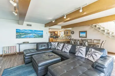 a living room with a leather couch and a table at Massive 3 bedroom on the sand-STR14-0133 in Dana Point