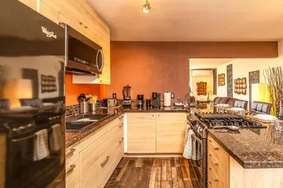 a kitchen with wooden cabinets and a stove top oven at Giraffe House in Chula Vista