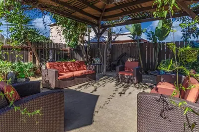 a patio with chairs and a couch and a pergola at Giraffe House in Chula Vista