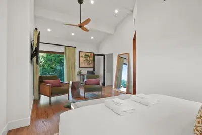 a white bedroom with two beds and a living room at Village Vistas - Walk to Beach and LJ Village, AC, Spa in San Diego