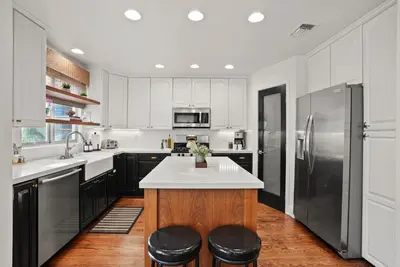 a kitchen with white cabinets and stainless steel appliances at Village Vistas - Walk to Beach and LJ Village, AC, Spa in San Diego
