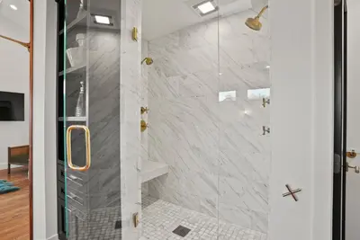 a bathroom with a shower with a glass door at Village Vistas - Walk to Beach and LJ Village, AC, Spa in San Diego