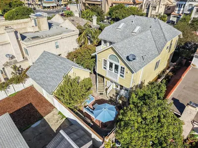 an overhead view of a yellow house with a blue umbrella at Lovely home with backyard oasis & great WiFi - walk to La Jolla Village, dogs OK in San Diego