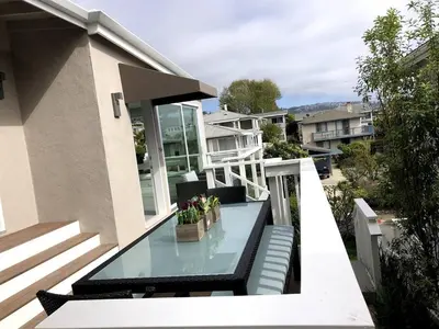 a balcony with a glass table on a house at Laguna Beach House in Laguna Beach