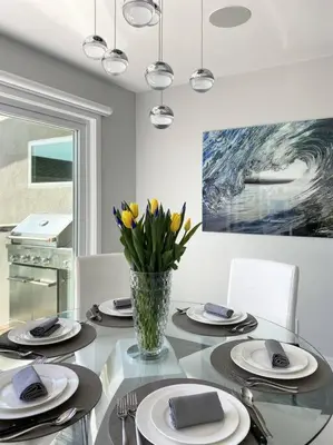 a dining room with a glass table with a vase of flowers at Laguna Beach House in Laguna Beach