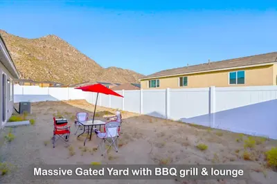 a patio with a table and chairs and an umbrella at Entire Private Home with 4 Bedrooms 2 Bathrooms, Mountain Edge, New House, Ranch, Gated Yard, Available Now in Menifee