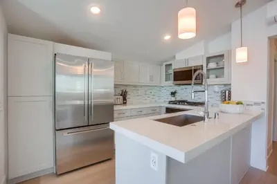 a kitchen with white cabinets and a stainless steel refrigerator at Bayside Cove 8 in San Diego