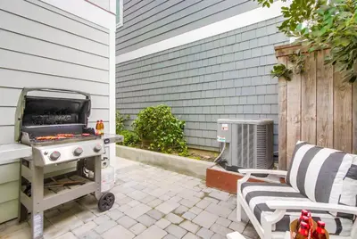 a barbecue grill on a patio next to a chair at The Shores 7 in San Diego