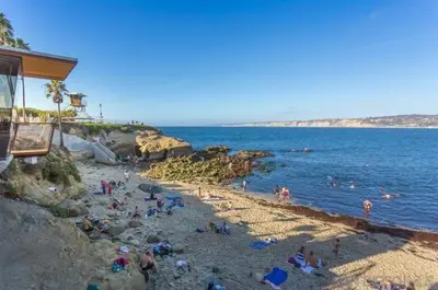 a group of people on a beach near the water at The Shores 7 in San Diego