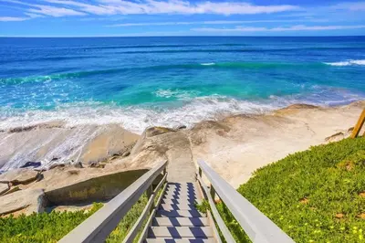 a staircase leading down to the beach with the ocean at Terramar Point in Carlsbad