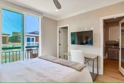 a bedroom with a bed and a desk and a balcony at Bayside Cove 7 in San Diego