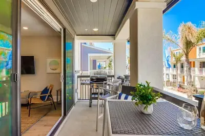 a living room with a table and a balcony at Bayside Cove 7 in San Diego