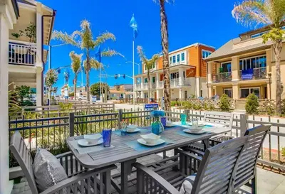 a wooden table with chairs on a balcony with palm trees at Bayside Cove 7 in San Diego