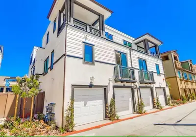 a white building with two garage doors on a street at Bayside Cove 7 in San Diego