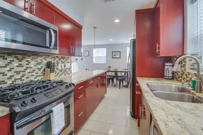a kitchen with red cabinets and a stove top oven at Ocean & Bay in San Diego