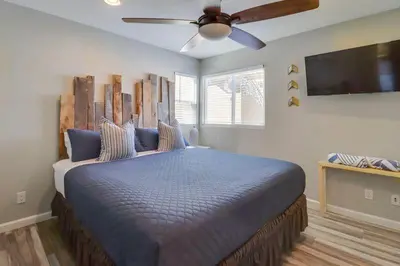 a bedroom with a large bed with a ceiling fan at Ocean & Bay in San Diego