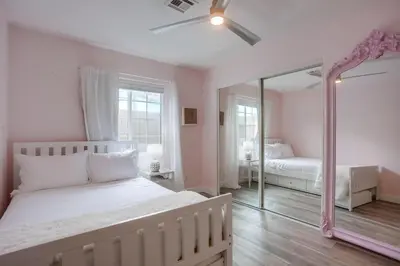 a bedroom with a white bed and a mirror at Pipeline in San Diego