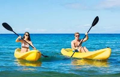 a man and woman in kayaks in the ocean at Pipeline in San Diego