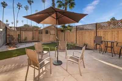 a patio with an umbrella and chairs and a table at Surf Cottage 1 in San Diego